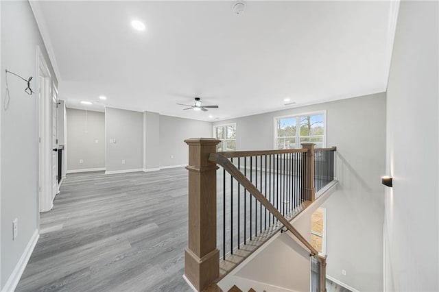 hallway with recessed lighting, baseboards, wood finished floors, and an upstairs landing