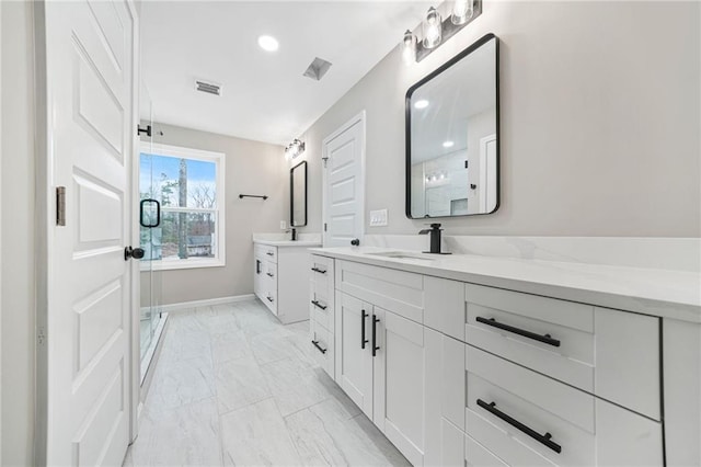 bathroom featuring marble finish floor, two vanities, visible vents, a stall shower, and a sink