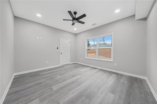 empty room featuring recessed lighting, visible vents, ceiling fan, wood finished floors, and baseboards