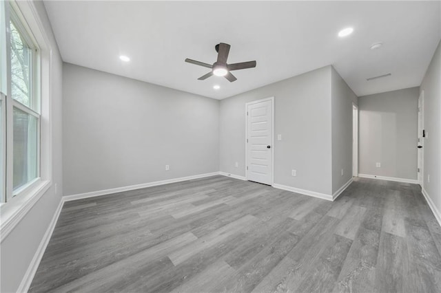 spare room with a ceiling fan, baseboards, wood finished floors, and recessed lighting