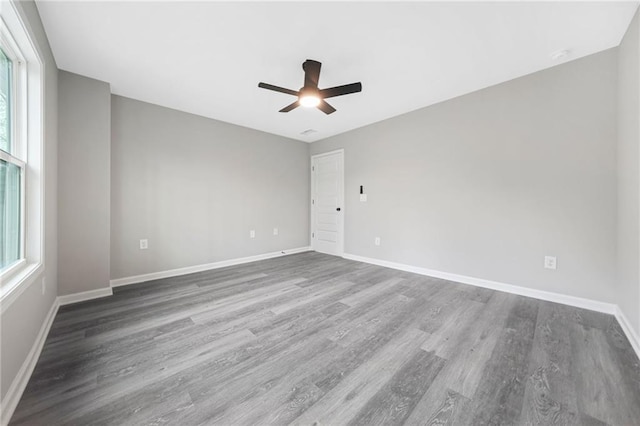 spare room featuring ceiling fan, wood finished floors, and baseboards