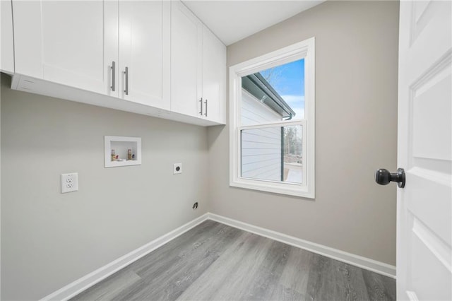 washroom with baseboards, dark wood finished floors, cabinet space, and hookup for an electric dryer