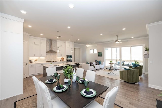 dining space with light wood-style flooring, ornamental molding, baseboards, and recessed lighting