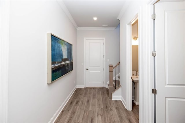 hall featuring crown molding, recessed lighting, light wood-type flooring, baseboards, and stairs