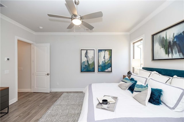 bedroom with baseboards, wood finished floors, a ceiling fan, and crown molding