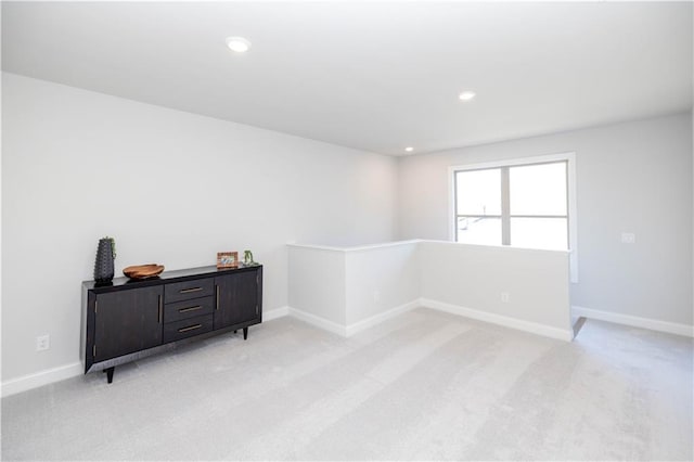 unfurnished room featuring recessed lighting, light colored carpet, and baseboards