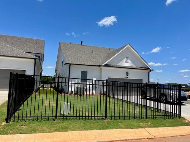 view of front facade featuring a fenced front yard, a front yard, driveway, and an attached garage