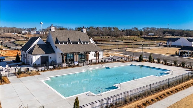 community pool featuring fence and a patio