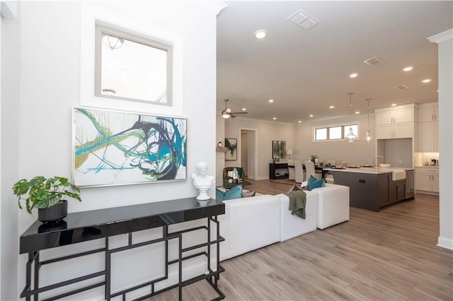 living room featuring light wood finished floors, visible vents, and recessed lighting