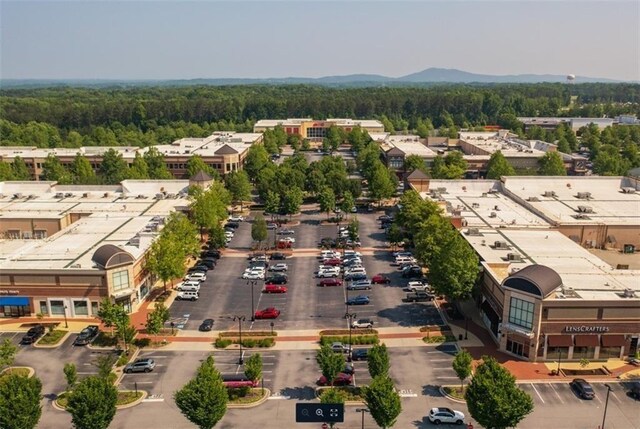 drone / aerial view featuring a wooded view and a mountain view