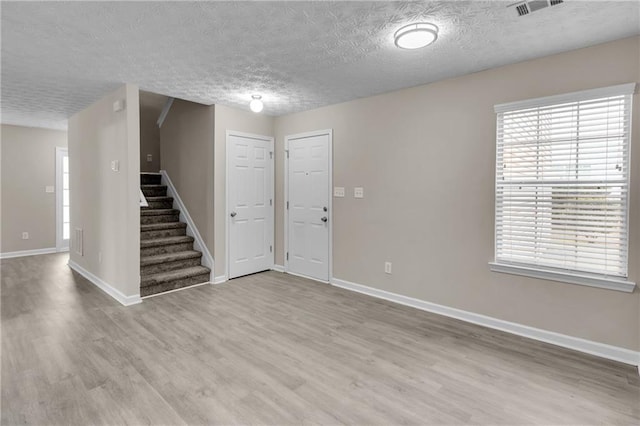 7185 Sweet Gum Ct, Lithonia, GA 30058 - interior space featuring stairway, a textured ceiling, baseboards, and wood finished floors