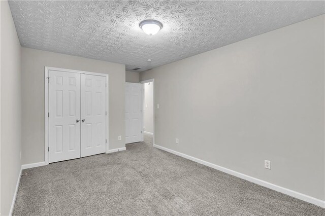 7185 Sweet Gum Ct, Lithonia, GA 30058 - unfurnished bedroom featuring a closet, baseboards, carpet flooring, and a textured ceiling