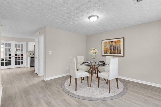 7185 Sweet Gum Ct, Lithonia, GA 30058 - dining space with light wood finished floors, baseboards, and a textured ceiling