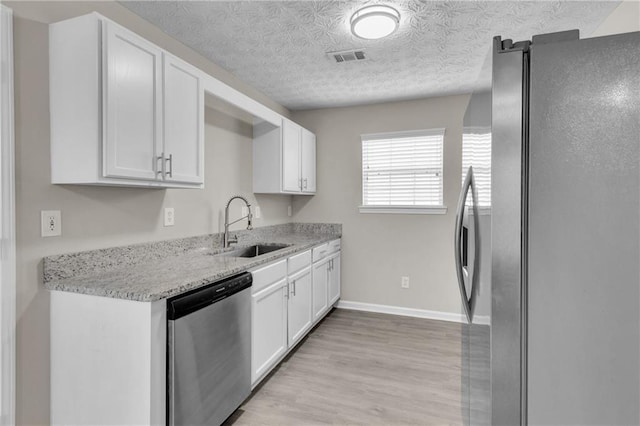 7185 Sweet Gum Ct, Lithonia, GA 30058 - kitchen with a sink, white cabinets, appliances with stainless steel finishes, and light wood-style flooring
