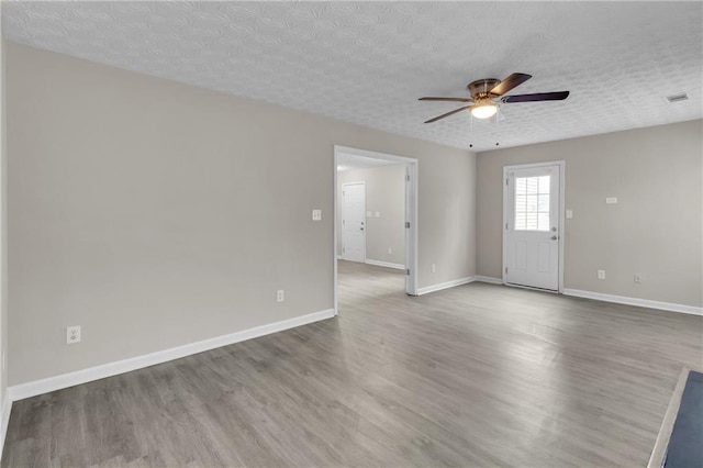 7185 Sweet Gum Ct, Lithonia, GA 30058 - spare room featuring baseboards, a textured ceiling, wood finished floors, and ceiling fan