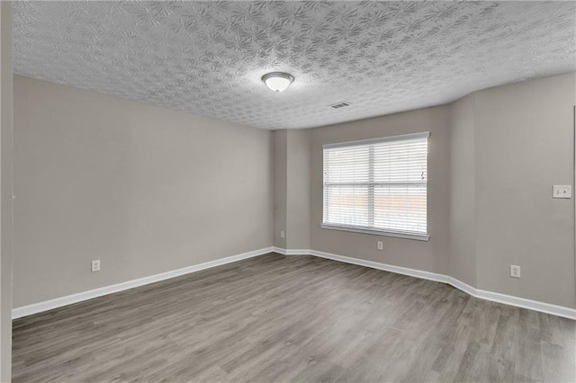 7185 Sweet Gum Ct, Lithonia, GA 30058 - empty room with a textured ceiling, wood finished floors, baseboards, and visible vents