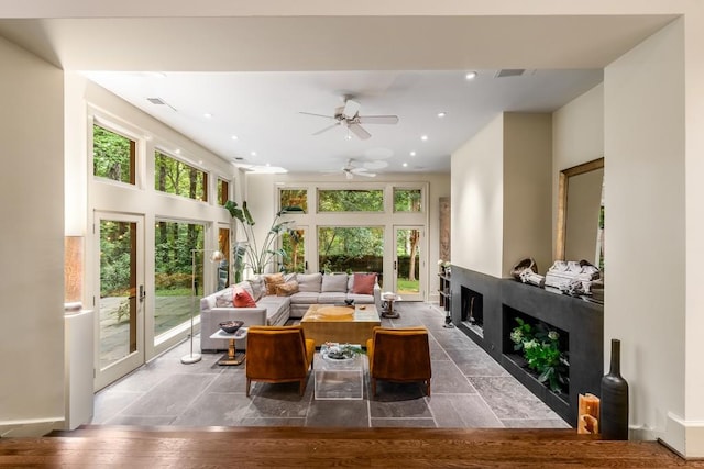 sunroom / solarium featuring french doors, a wealth of natural light, and ceiling fan