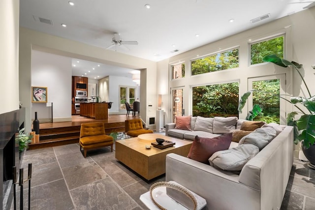 living room featuring ceiling fan and a high ceiling