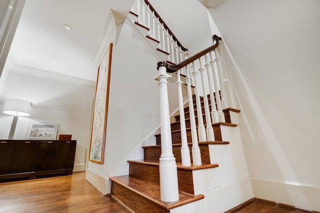 staircase featuring hardwood / wood-style flooring and crown molding