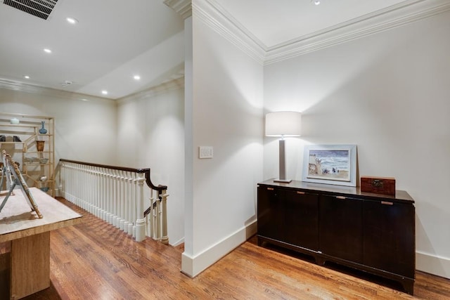 hallway featuring light wood-type flooring and ornamental molding