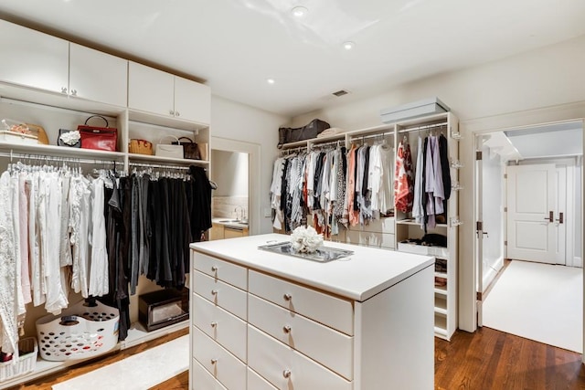 walk in closet with dark wood-type flooring