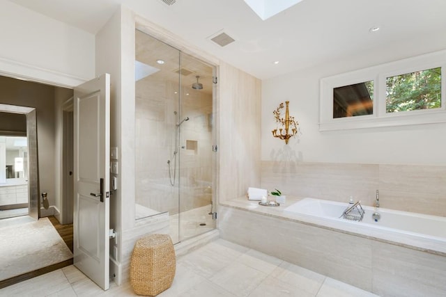 bathroom featuring shower with separate bathtub, a skylight, and tile patterned floors