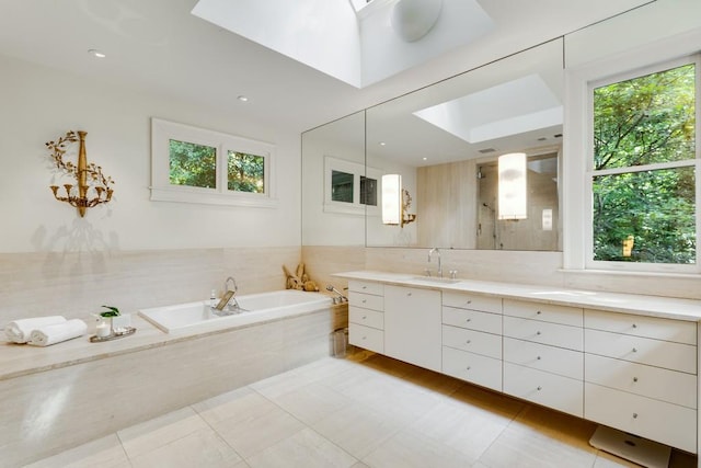 bathroom featuring tile patterned flooring, vanity, a skylight, and a healthy amount of sunlight