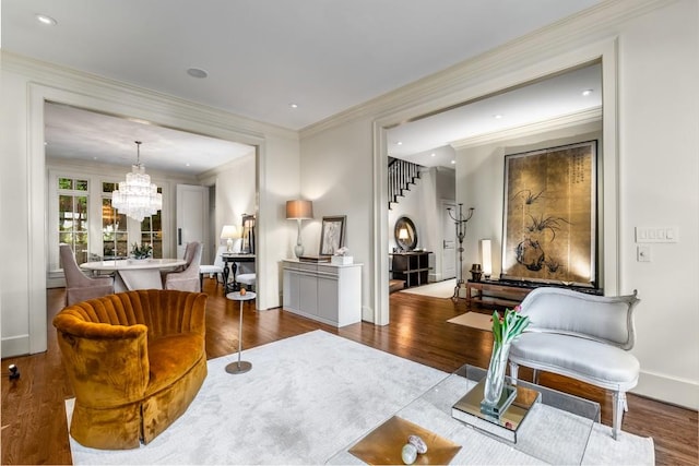 living area with a chandelier, dark hardwood / wood-style flooring, and crown molding