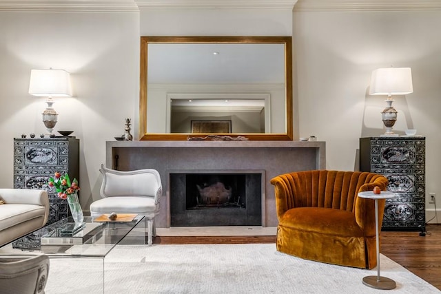 sitting room with hardwood / wood-style floors and ornamental molding