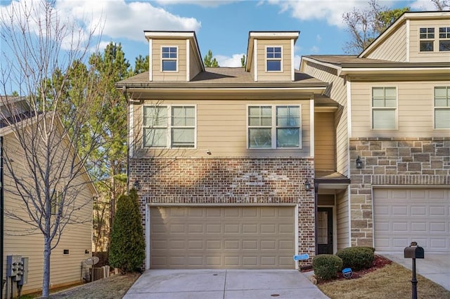 view of front of home with concrete driveway, brick siding, a garage, and stone siding