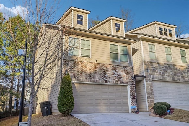 view of front of home with stone siding, brick siding, a garage, and driveway