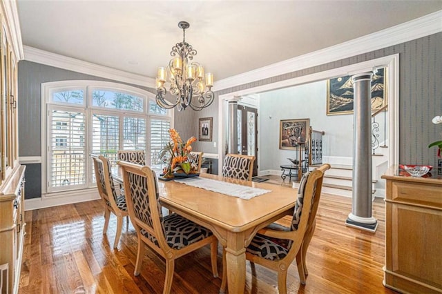 dining space with ornamental molding, light wood finished floors, decorative columns, and baseboards