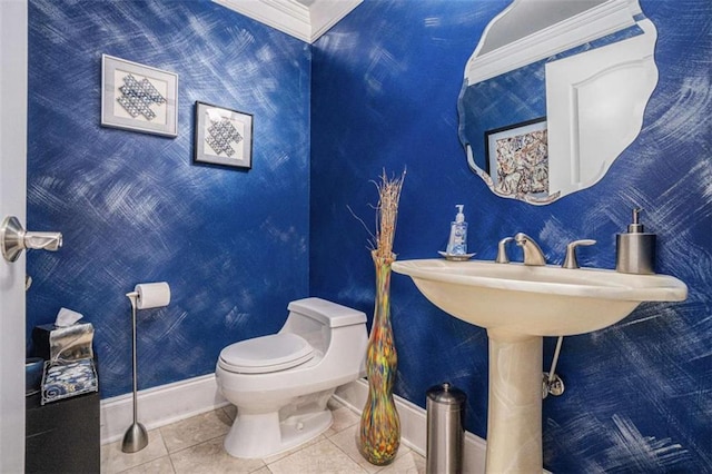 half bathroom with toilet, baseboards, ornamental molding, and tile patterned floors