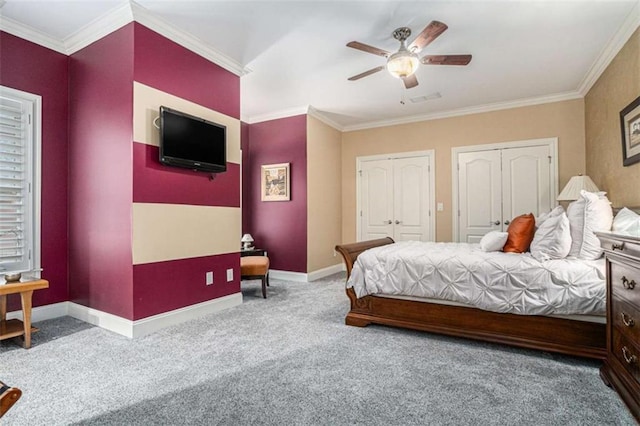 bedroom with ornamental molding, carpet flooring, two closets, and baseboards