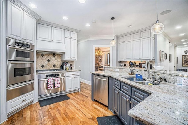 kitchen with appliances with stainless steel finishes, a sink, crown molding, a warming drawer, and exhaust hood