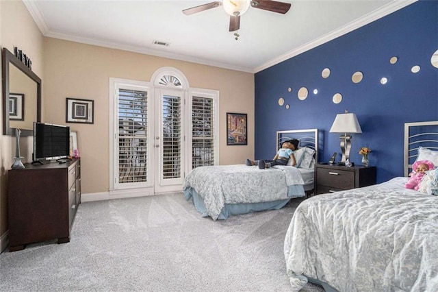 carpeted bedroom with ceiling fan, an accent wall, baseboards, access to outside, and crown molding