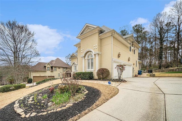 view of side of home featuring concrete driveway and stucco siding