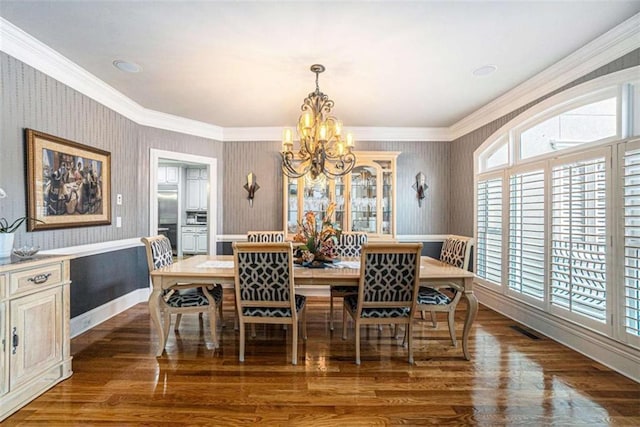 dining room featuring wood finished floors, visible vents, and wallpapered walls