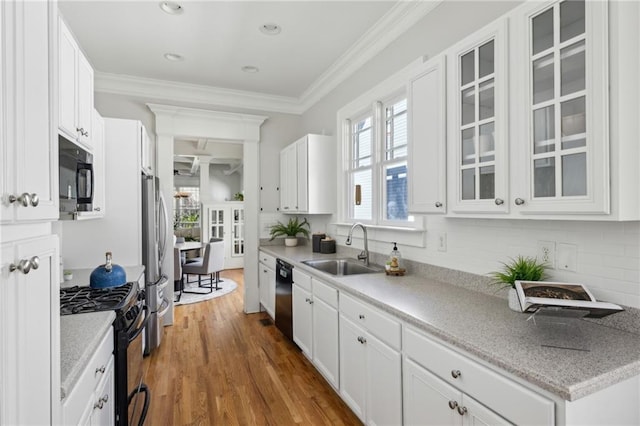 kitchen with dark hardwood / wood-style floors, white cabinetry, sink, ornamental molding, and black appliances