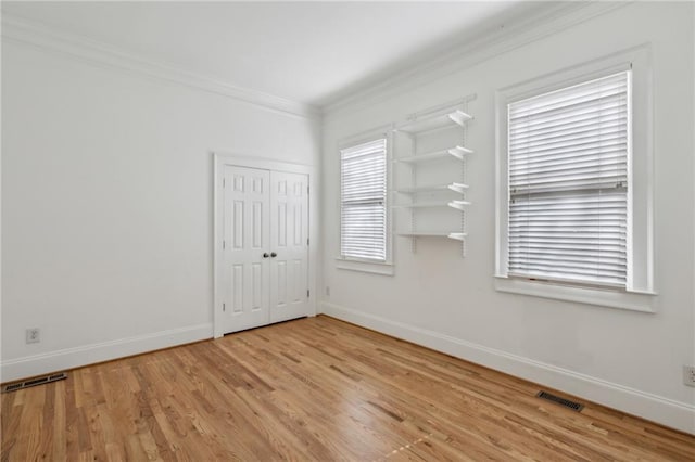 spare room featuring crown molding and light wood-type flooring