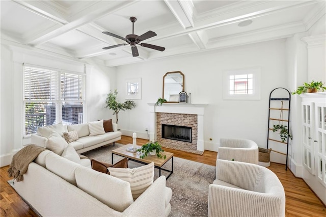 living room with hardwood / wood-style flooring, coffered ceiling, a brick fireplace, and beamed ceiling