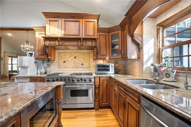 kitchen featuring stainless steel appliances, a sink, and brown cabinets