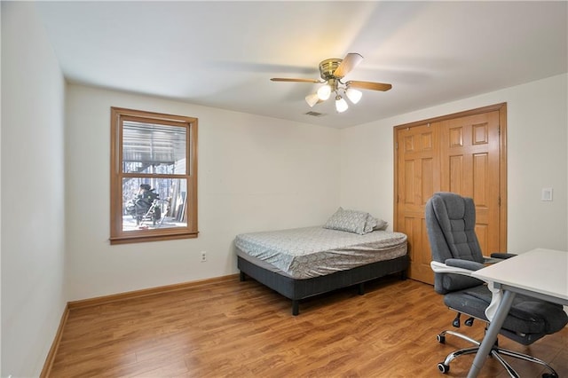 bedroom with visible vents, baseboards, ceiling fan, and wood finished floors