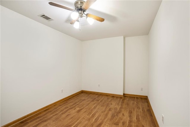 unfurnished room with a ceiling fan, baseboards, visible vents, and wood finished floors