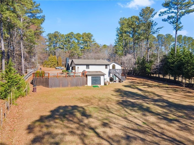 rear view of property with a lawn and stairs