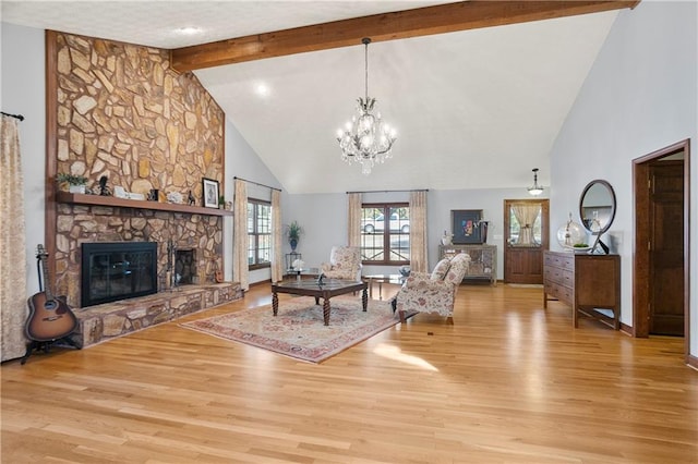 living area featuring high vaulted ceiling, a stone fireplace, a notable chandelier, light wood-style floors, and beamed ceiling