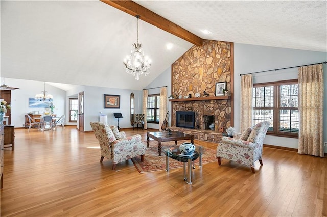 living area featuring a chandelier, a healthy amount of sunlight, a fireplace, and light wood-style flooring