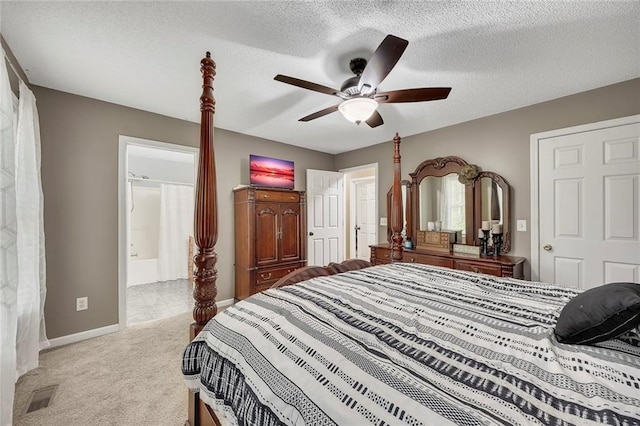 carpeted bedroom featuring visible vents, baseboards, ensuite bathroom, a textured ceiling, and a ceiling fan