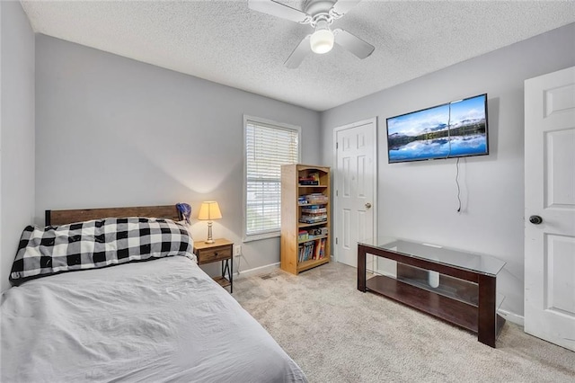 bedroom featuring baseboards, a textured ceiling, carpet, and ceiling fan