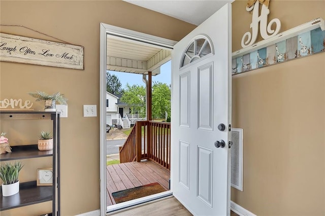 entryway with baseboards, wood finished floors, and visible vents
